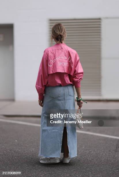 Karin Teigl seen wearing Christian Dior Sports pink vintage jacket, Agolde light blue denim long skirt, Louis Vuitton white canvas with colorful logo...