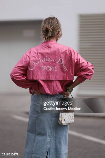 Karin Teigl seen wearing Christian Dior Sports pink vintage jacket, Agolde light blue denim long skirt, Louis Vuitton white canvas with colorful logo...