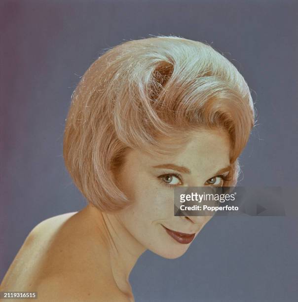 Posed studio portrait of a female fashion model with her blonde hair styled into a modern bouffant bob hairstyle, London, 23rd February 1963.