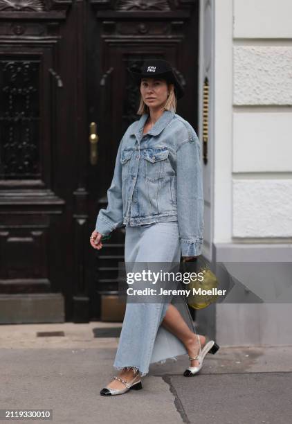 Karin Teigl seen wearing Miu Miu black cowboy hat, Agolde light blue denim jacket, Agolde light blue denim long skirt, Miu Miu green bracelet, Prada...