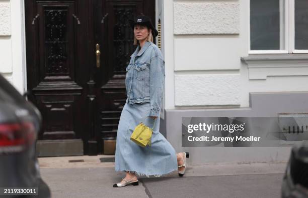 Karin Teigl seen wearing Miu Miu black cowboy hat, Agolde light blue denim jacket, Agolde light blue denim long skirt, Miu Miu green bracelet, Prada...