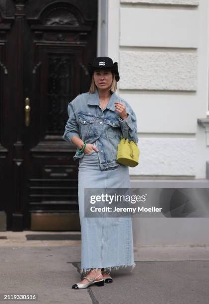 Karin Teigl seen wearing Miu Miu black cowboy hat, Agolde light blue denim jacket, Agolde light blue denim long skirt, Miu Miu green bracelet, Prada...