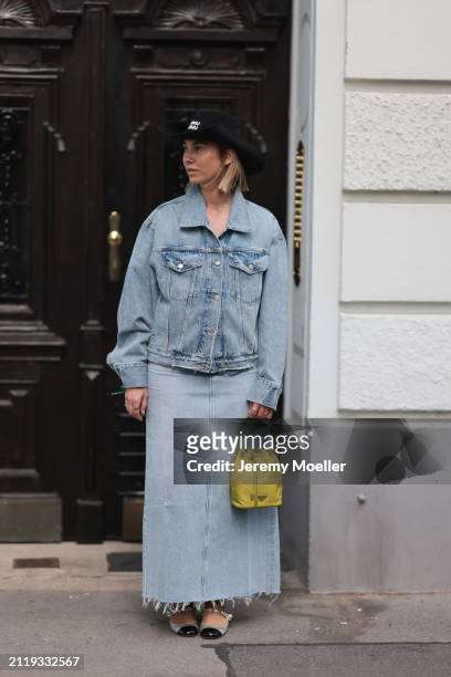 Karin Teigl seen wearing Miu Miu black cowboy hat, Agolde light blue denim jacket, Agolde light blue denim long skirt, Miu Miu green bracelet, Prada...