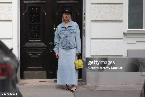 Karin Teigl seen wearing Miu Miu black cowboy hat, Agolde light blue denim jacket, Agolde light blue denim long skirt, Miu Miu green bracelet, Prada...