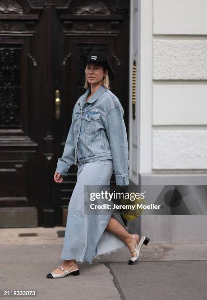 Karin Teigl seen wearing Miu Miu black cowboy hat, Agolde light blue denim jacket, Agolde light blue denim long skirt, Miu Miu green bracelet, Prada...