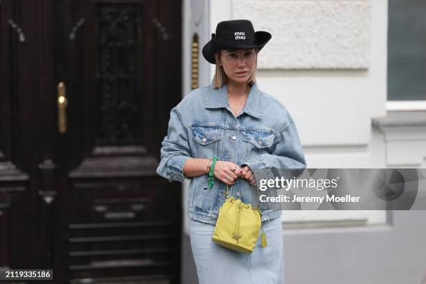 Karin Teigl seen wearing Miu Miu black cowboy hat, Agolde light blue denim jacket, Agolde light blue denim long skirt, Miu Miu green bracelet, Prada...