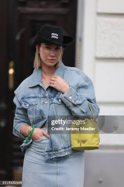 Karin Teigl seen wearing Miu Miu black cowboy hat, Agolde light blue denim jacket, Agolde light blue denim long skirt, Miu Miu green bracelet, Prada...