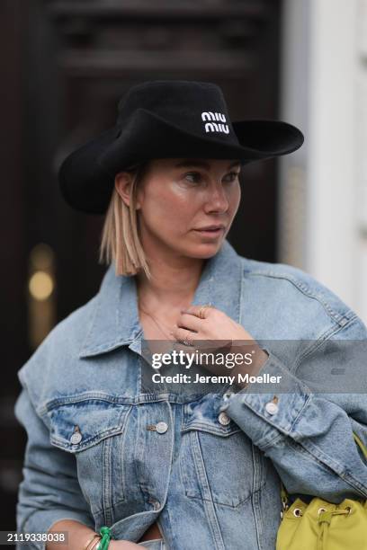 Karin Teigl seen wearing Miu Miu black cowboy hat, Agolde light blue denim jacket, Miu Miu green bracelet, Prada Re-edition lime green nylon mini...