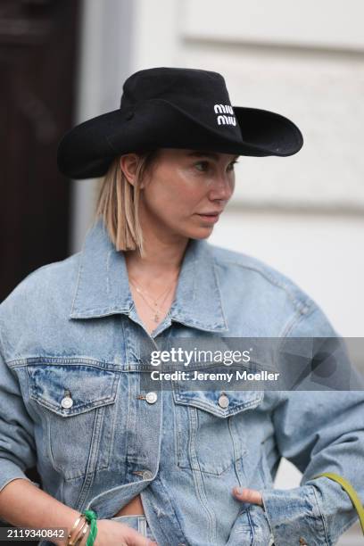 Karin Teigl seen wearing Miu Miu black cowboy hat, Agolde light blue denim jacket, Miu Miu green bracelet, on March 23, 2024 in Munich, Germany.