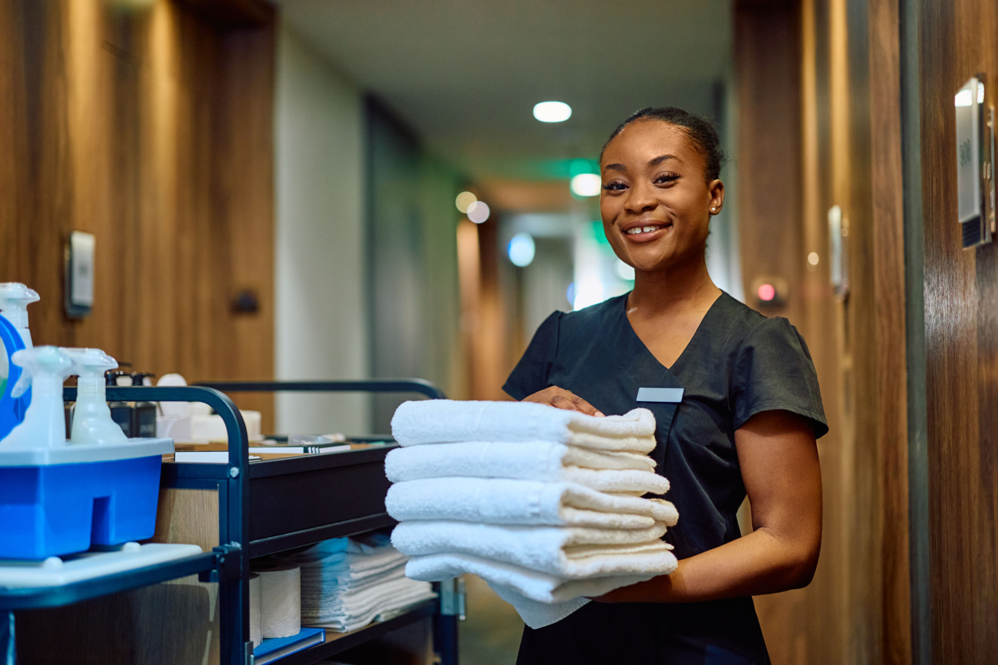 Happy black hotel man with stack of clean towels looking at camera. Happy black hotel man with stack of clean towels looking at camera.