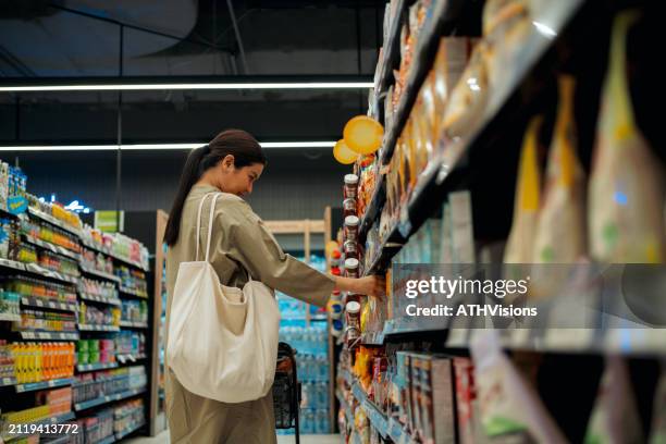 selecting snacks at the supermarket - voorraadkast stockfoto's en -beelden
