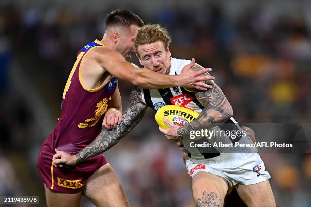 Beau McCreery of the Magpies is tackled high by Darcy Wilmot of the Lions during the round three AFL match between Brisbane Lions and Collingwood...