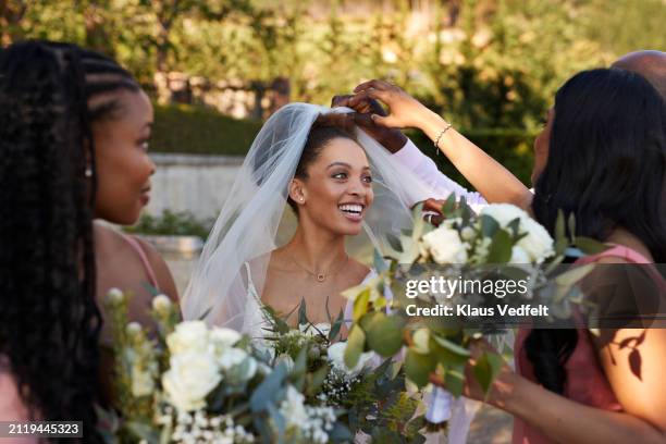 bridesmaid and father adjusting veil for young bride - bridal dress alteration stock pictures, royalty-free photos & images