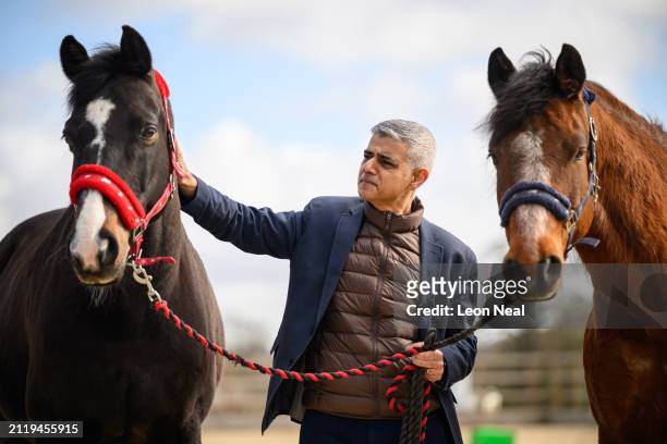 Mayor of London Sadiq Khan stands with horses at the Strength and Learning through Horses equine therapy centre at Green Gates stables on March 28,...