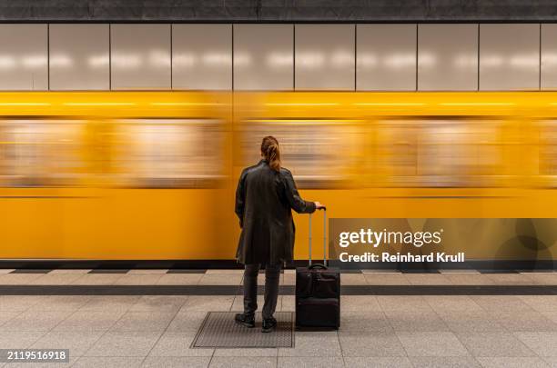 rear view of woman standing in front of arriving subway train - back of leather jacket stock pictures, royalty-free photos & images