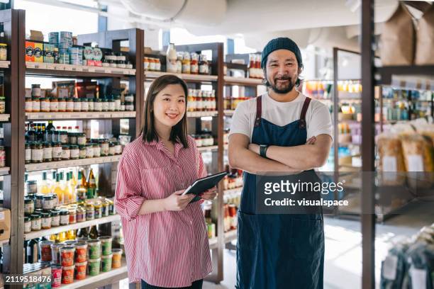 japanese organic convenience store owners stand side by side, exuding confidence and positivity - exuding stock pictures, royalty-free photos & images