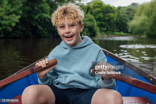 boy rowing down river - rowing boat stock pictures, royalty-free photos & images