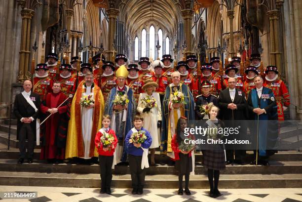 Queen Camilla holds the Nosegay bouquets as she poses with Yeomen of the Guard and and religious representatives during The Royal Maundy Service at...