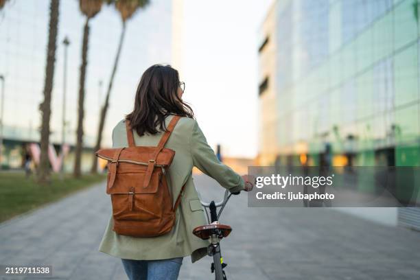 jeune femme marchant à côté avec un vélo - à côté de photos et images de collection