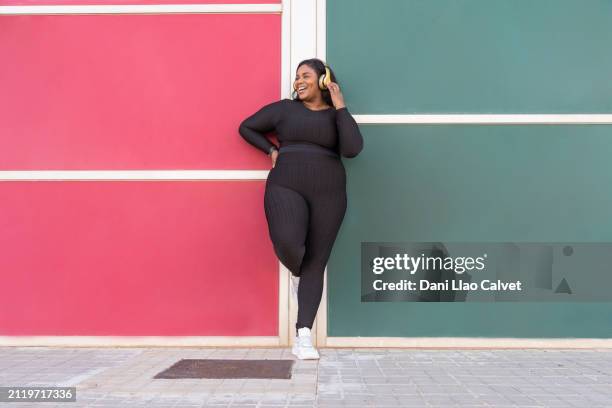 plus size woman listening to music - voluptuoso fotografías e imágenes de stock