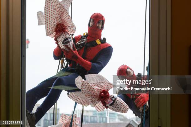 Rope access workers wearing comic-based superhero Spiderman costumes donate Easter eggs to hospitalized children at Clinica Pediatrica De Marchi on...