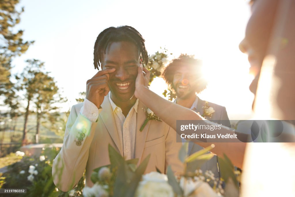 Bride consoling groom crying with joy