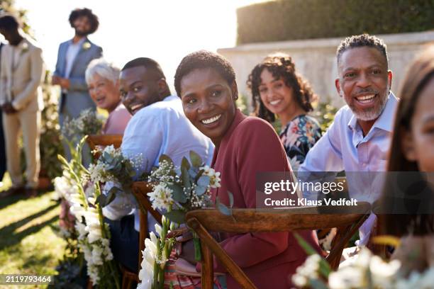 happy male and female guests looking back - homme africain assis habit traditionnel photos et images de collection