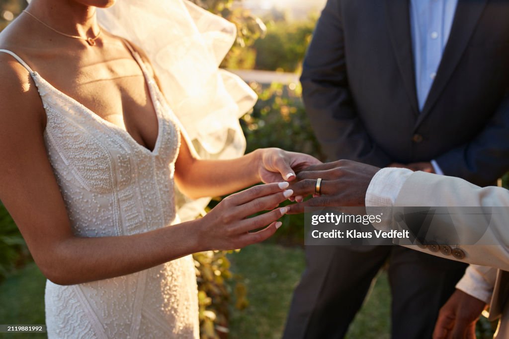 Young bride exchanging wedding ring with groom