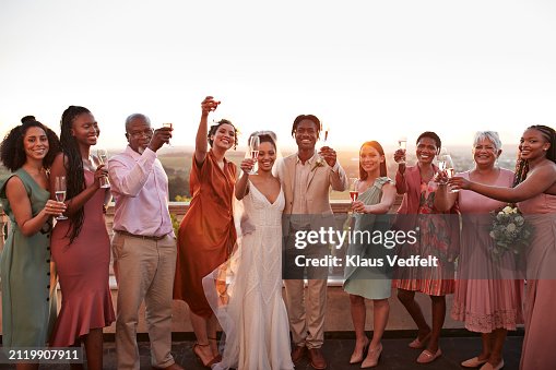 Happy just married couple and guests toasting drinks Happy just married couple and guests toasting drinks