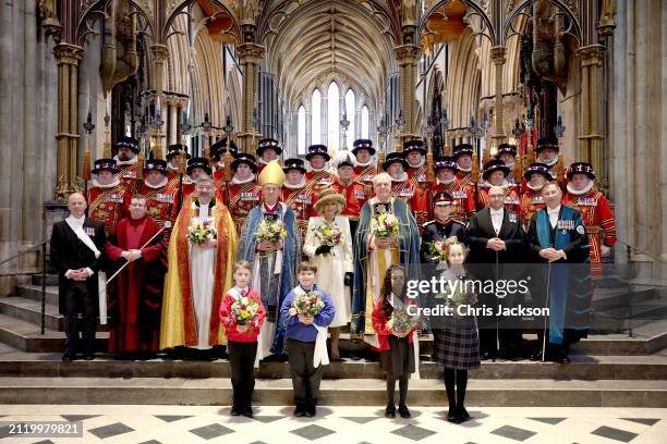 Queen Camilla holds a traditional Nosegay bouquet as she poses with Yeomen of the Guard and and religious representatives during The Royal Maundy...