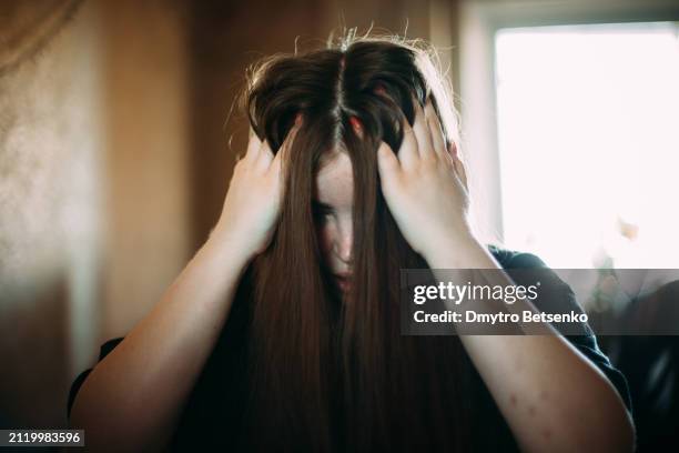 depressed young woman sitting at home - terrified stock pictures, royalty-free photos & images