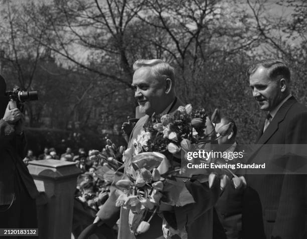Soviet Premier Nikolai Bulganin holding a bouquet of flowers during a visit to London, April 21st 1956.