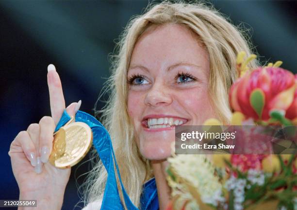 Inge de Bruijn from the Netherlands stands on the victory podium with the gold medal and gives the number one finger sign after winning the Women's...