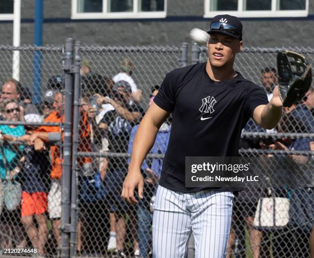 New York Yankees Aaron Judge warming up his arm with a large crowd watching during spring training workout at George M. Steinbrenner Field, in Tampa,...