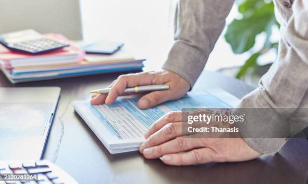 close-up of a man holding a tax form, - us federal trade commission stock pictures, royalty-free photos & images