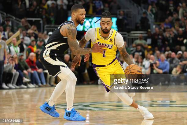Angelo Russell of the Los Angeles Lakers is defended by Damian Lillard of the Milwaukee Bucks during a game at Fiserv Forum on March 26, 2024 in...