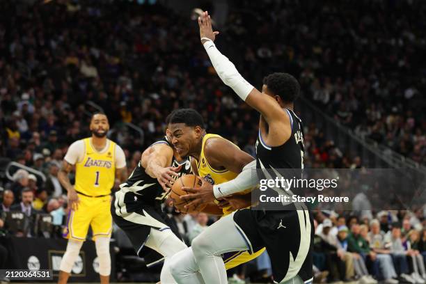 Rui Hachimura of the Los Angeles Lakers is defended by Giannis Antetokounmp and Malik Beasley of the Milwaukee Bucks during a game at Fiserv Forum on...