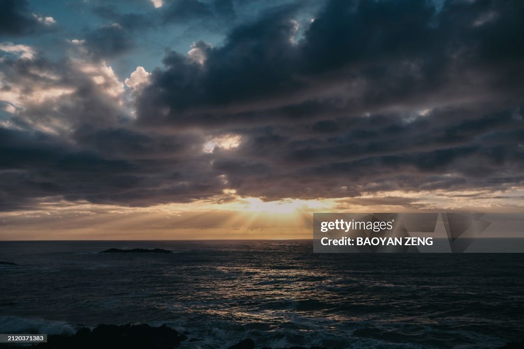 Sunrise over the ocean with cloudy and golden sky