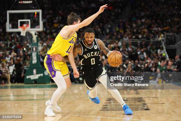 Damian Lillard of the Milwaukee Bucks is defended by Austin Reaves of the Los Angeles Lakers during a game at Fiserv Forum on March 26, 2024 in...