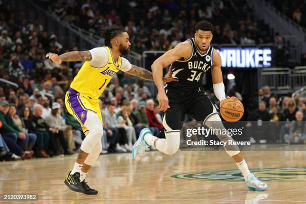 Giannis Antetokounmpo of the Milwaukee Bucks drives around D'Angelo Russell of the Los Angeles Lakers during a game at Fiserv Forum on March 26, 2024...