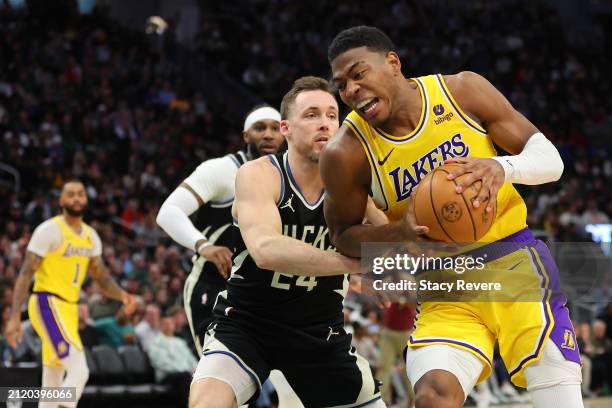 Rui Hachimura of the Los Angeles Lakers drives around Pat Connaughton of the Milwaukee Bucks during a game at Fiserv Forum on March 26, 2024 in...