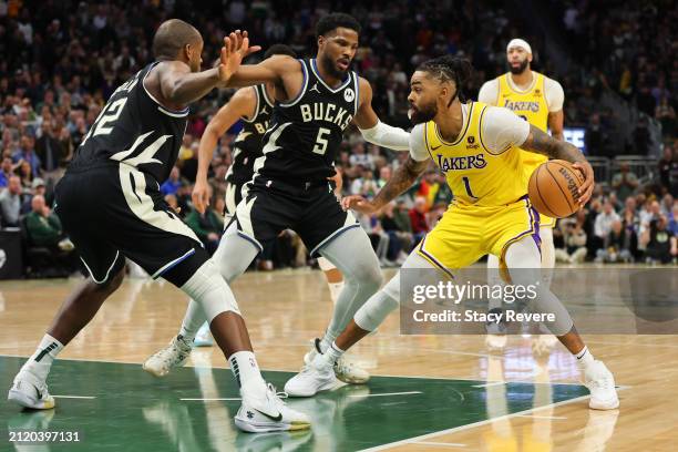 Angelo Russell of the Los Angeles Lakers is defended by Khris Middleton and Malik Beasley of the Milwaukee Bucks during a game at Fiserv Forum on...