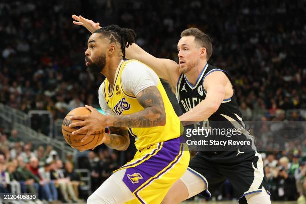 Angelo Russell of the Los Angeles Lakers drives around Pat Connaughton of the Milwaukee Bucks during a game at Fiserv Forum on March 26, 2024 in...