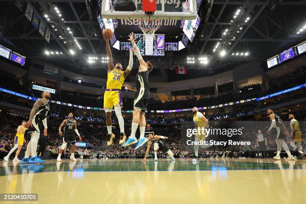 Rui Hachimura of the Los Angeles Lakers is defended by Brook Lopez of the Milwaukee Bucks during a game at Fiserv Forum on March 26, 2024 in...