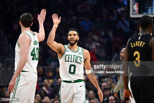 Luke Kornet celebrates with Jayson Tatum of the Boston Celtics during the first half against the Cleveland Cavaliers at Rocket Mortgage Fieldhouse on...