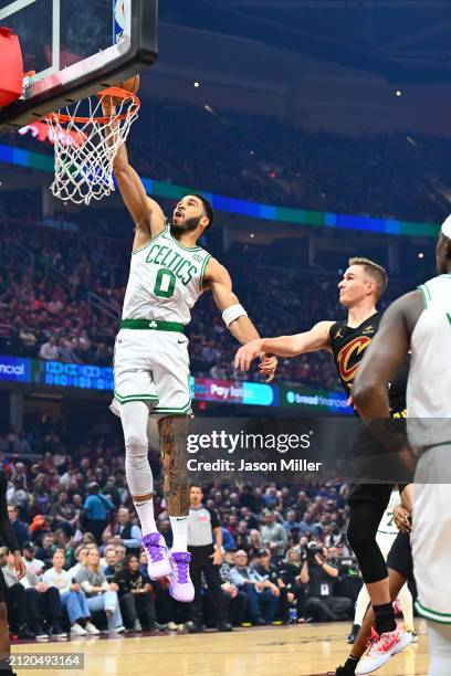 Jayson Tatum of the Boston Celtics dunks over Sam Merrill of the Cleveland Cavaliers during the first half at Rocket Mortgage Fieldhouse on March 05,...