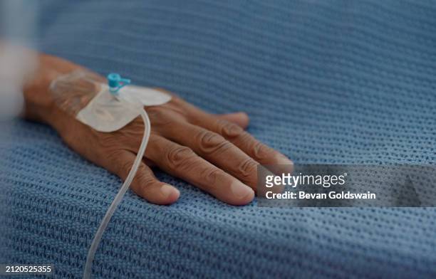 hand, intravenous medication and patient in hospital, clinic and healthcare facility for health or healing. bed, senior person and medical equipment for intensive care, life support and medicine - vitamin iv stock pictures, royalty-free photos & images