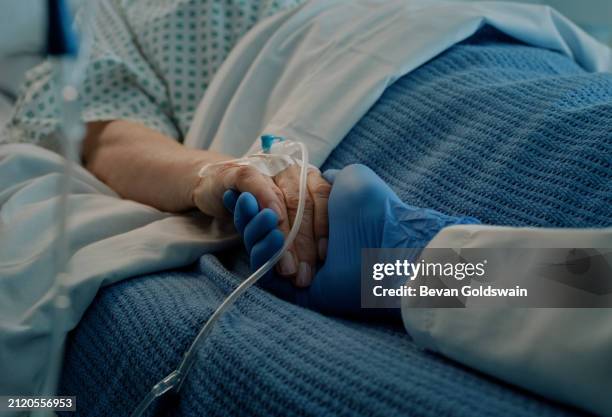 krankenhaus, händchen halten und bett mit arzt, unterstützung und pflege gemeinsam in einer klinik nach der operation. senior, gesundheits- und krebspatient mit einfühlungsvermögen, freundlichkeit und pflegekraft mit mitgefühl mit hilfe - cancer patient in hospital bed stock-fotos und bilder