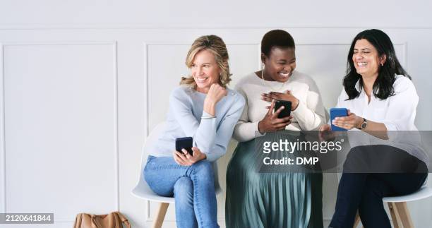 diversity, smile and women in waiting room with phone, talking or connection at recruitment agency. technology, networking and group of people at job interview together with smartphone with mockup - interview icon stock pictures, royalty-free photos & images