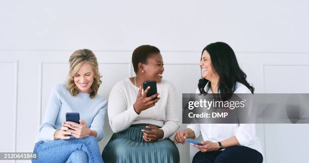 diversity, friends and women in waiting room with phone, talking or social media connection at recruitment agency. technology, networking and group of people at job interview together with smartphone - interview icon stock pictures, royalty-free photos & images